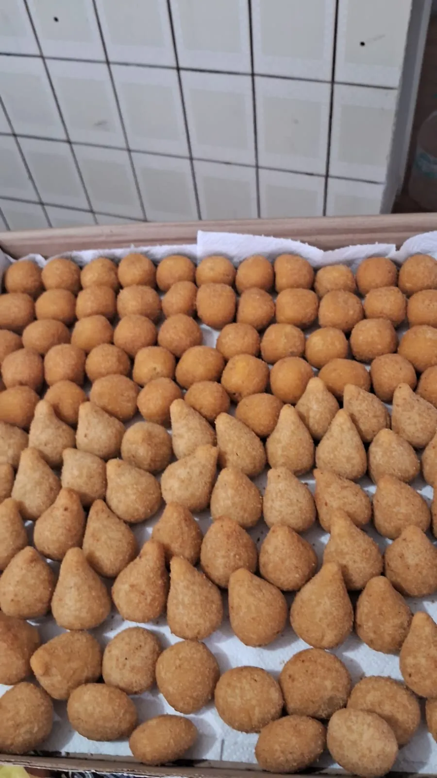Bandeja com fileiras de coxinhas e bolinhas fritas
